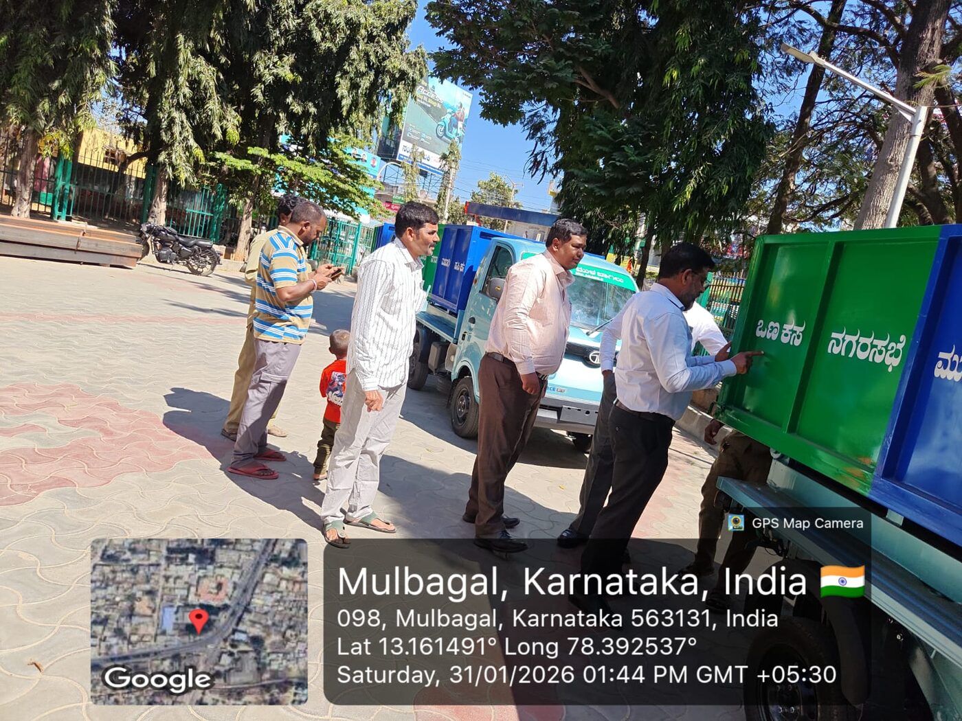 Officials pointing out the labeled waste compartments